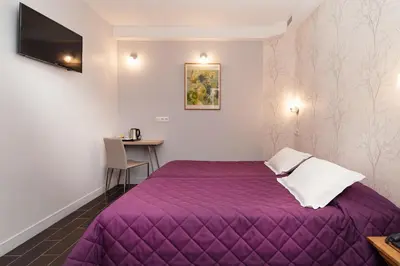 Un ou plusieurs lits dans un hébergement de l'établissement Hotel Americain