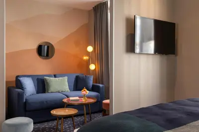 Télévision ou salle de divertissement dans l'établissement Hôtel Maxim Folies