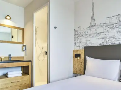 Un ou plusieurs lits dans un hébergement de l'établissement Greet Hotel Paris porte de la Chapelle - Aréna