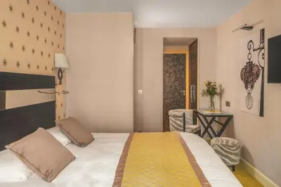 Un ou plusieurs lits dans un hébergement de l'établissement Hotel Le petit Paris