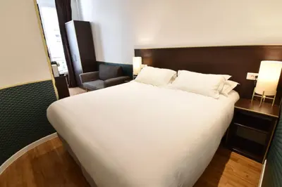 Un ou plusieurs lits dans un hébergement de l'établissement Hôtel Bonne Nouvelle