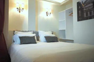 Un ou plusieurs lits dans un hébergement de l'établissement Louvre Opera Classic ChicSuites