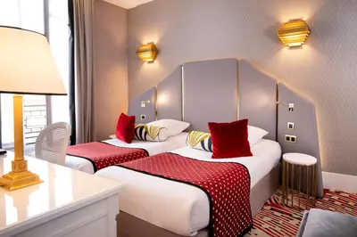 Un ou plusieurs lits dans un hébergement de l'établissement Hôtel Victor Hugo Paris Kléber
