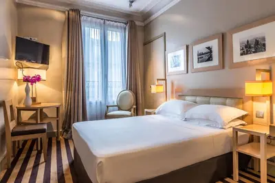 Un ou plusieurs lits dans un hébergement de l'établissement Hotel Duret Paris Champs Elysées