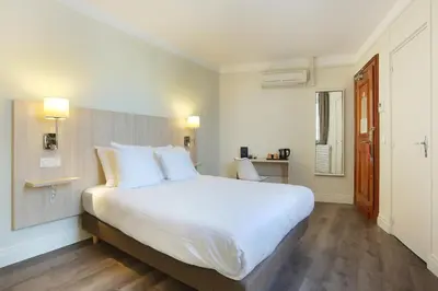 Un ou plusieurs lits dans un hébergement de l'établissement Hotel Murat