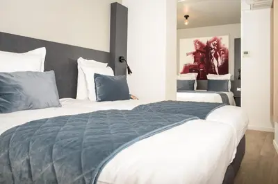 Un ou plusieurs lits dans un hébergement de l'établissement Hôtel Des Arts-Bastille