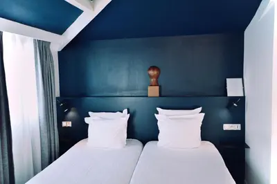 Un ou plusieurs lits dans un hébergement de l'établissement Hôtel Lucien