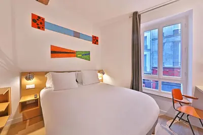 Un ou plusieurs lits dans un hébergement de l'établissement Hôtel Louvre Richelieu