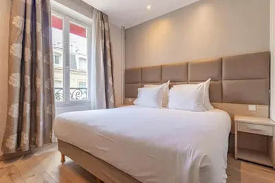 Un ou plusieurs lits dans un hébergement de l'établissement Hotel Riviera OPERA Cadet