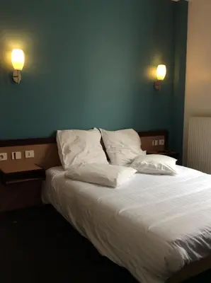 Un ou plusieurs lits dans un hébergement de l'établissement Hotel De La Place
