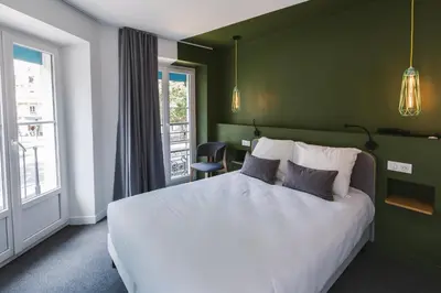 Un ou plusieurs lits dans un hébergement de l'établissement Le Petit Cosy Hôtel