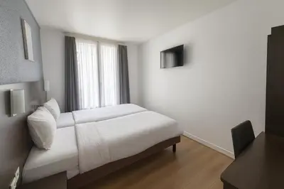 Un ou plusieurs lits dans un hébergement de l'établissement Hotel Arc Paris Porte d'Orléans