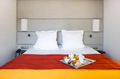 Un ou plusieurs lits dans un hébergement de l'établissement Hôtel Paris Neuilly