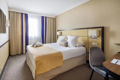 Un ou plusieurs lits dans un hébergement de l'établissement Hôtel Paris Neuilly