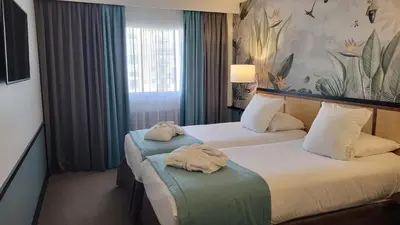 Un ou plusieurs lits dans un hébergement de l'établissement Hôtel Paris Neuilly