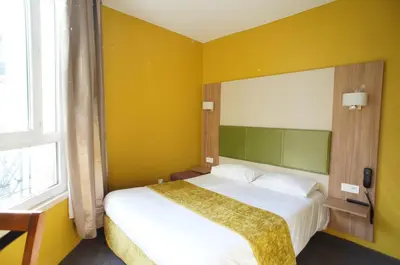 Un ou plusieurs lits dans un hébergement de l'établissement Hôtel De France