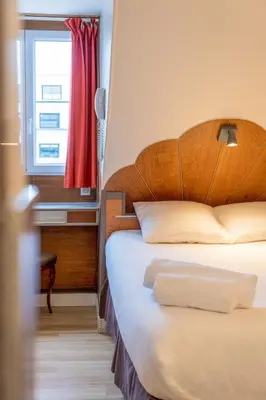Un ou plusieurs lits dans un hébergement de l'établissement Hôtel Marignan