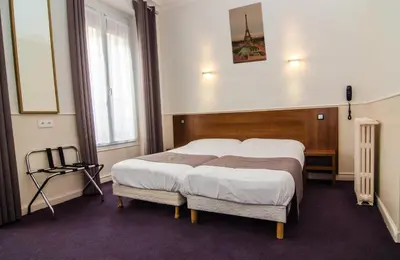 Un ou plusieurs lits dans un hébergement de l'établissement Hotel Paris Bruxelles