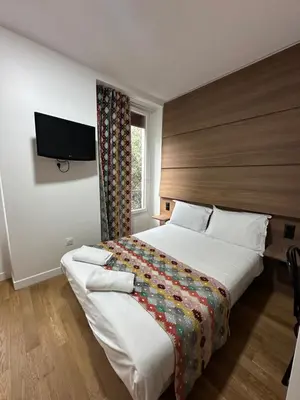 Un ou plusieurs lits dans un hébergement de l'établissement Hotel Paris Bruxelles