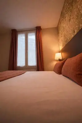 Un ou plusieurs lits dans un hébergement de l'établissement Parici Hôtel Boulogne Billancourt