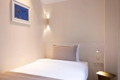 Un ou plusieurs lits dans un hébergement de l'établissement Hôtel Le Daum