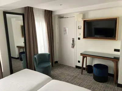 Télévision ou salle de divertissement dans l'établissement Le Grand Hôtel de Normandie