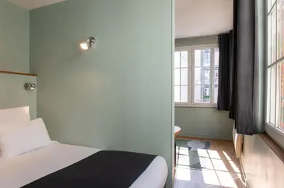 Un ou plusieurs lits dans un hébergement de l'établissement Hôtel Helzear Montparnasse by Esteem