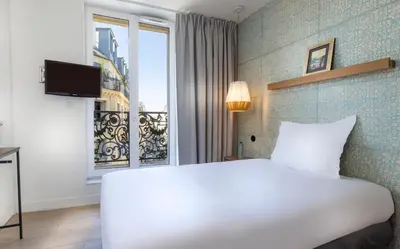 Un ou plusieurs lits dans un hébergement de l'établissement Hôtel Emile Le Marais