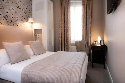 Un ou plusieurs lits dans un hébergement de l'établissement Hôtel Plaza Étoile