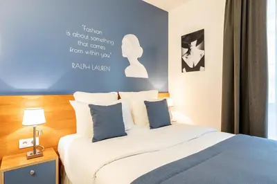 Un ou plusieurs lits dans un hébergement de l'établissement Hôtel Villa Eiffel Mademoiselle