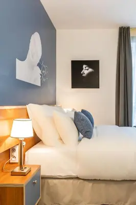 Un ou plusieurs lits dans un hébergement de l'établissement Hôtel Villa Eiffel Mademoiselle