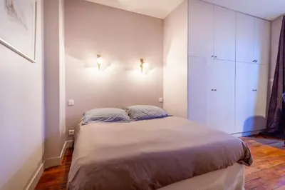 Un ou plusieurs lits dans un hébergement de l'établissement Greeter-Appartement Haussmannien avec balcon