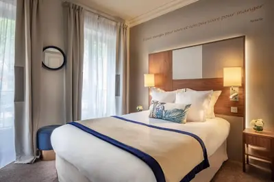Un ou plusieurs lits dans un hébergement de l'établissement Hôtel Le Tourville by Inwood Hotels