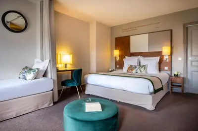 Un ou plusieurs lits dans un hébergement de l'établissement Hôtel Le Tourville by Inwood Hotels