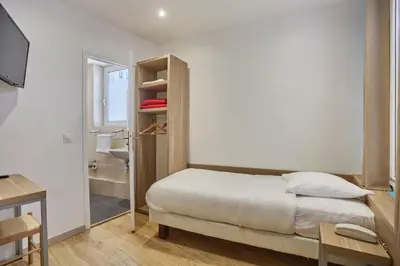 Un ou plusieurs lits dans un hébergement de l'établissement Merryl Hotel