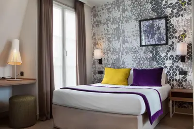Un ou plusieurs lits dans un hébergement de l'établissement Hotel des Nations Saint Germain