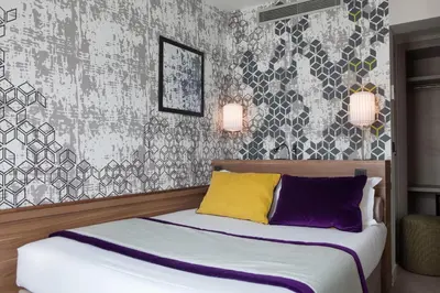 Un ou plusieurs lits dans un hébergement de l'établissement Hotel des Nations Saint Germain