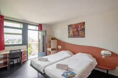 Un ou plusieurs lits dans un hébergement de l'établissement Hotel CIS Paris Maurice Ravel