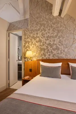 Un ou plusieurs lits dans un hébergement de l'établissement Timhotel Le Louvre