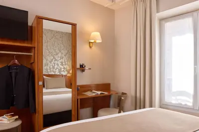 Un ou plusieurs lits dans un hébergement de l'établissement Timhotel Le Louvre