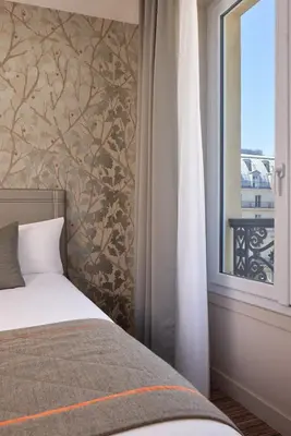 Un ou plusieurs lits dans un hébergement de l'établissement Timhotel Le Louvre