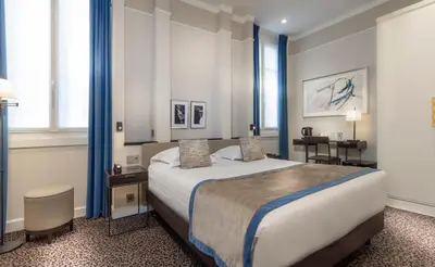 Un ou plusieurs lits dans un hébergement de l'établissement Hôtel Du Bois Champs-Elysées