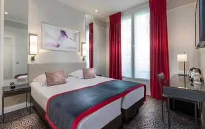 Un ou plusieurs lits dans un hébergement de l'établissement Hôtel Du Bois Champs-Elysées