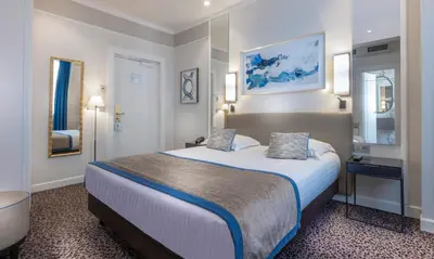 Un ou plusieurs lits dans un hébergement de l'établissement Hôtel Du Bois Champs-Elysées