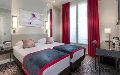 Un ou plusieurs lits dans un hébergement de l'établissement Hôtel Du Bois Champs-Elysées