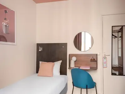 Un ou plusieurs lits dans un hébergement de l'établissement Hôtel Biskui