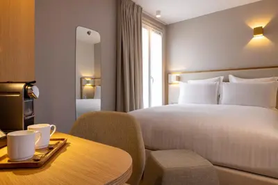 Un ou plusieurs lits dans un hébergement de l'établissement Hôtel Beige