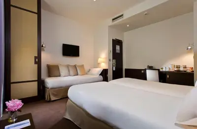 Un ou plusieurs lits dans un hébergement de l'établissement Hôtel Le Colisée