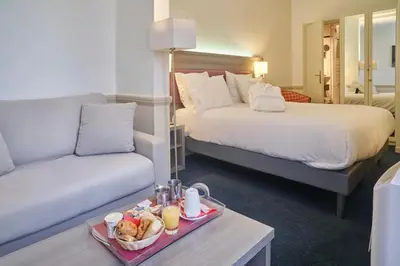 Un ou plusieurs lits dans un hébergement de l'établissement Hôtel Poussin