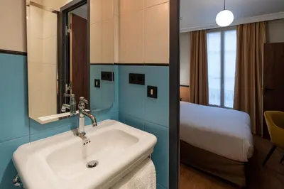 Un ou plusieurs lits dans un hébergement de l'établissement Hotel Terminus Lyon